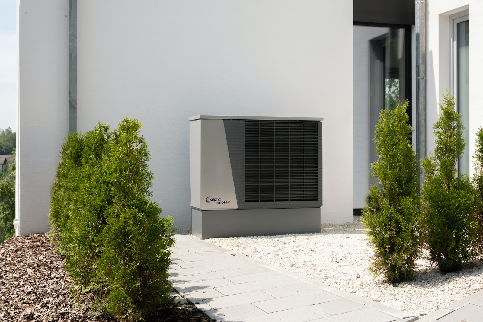 Photo by alpha innotec a air conditioner sitting on the side of a building