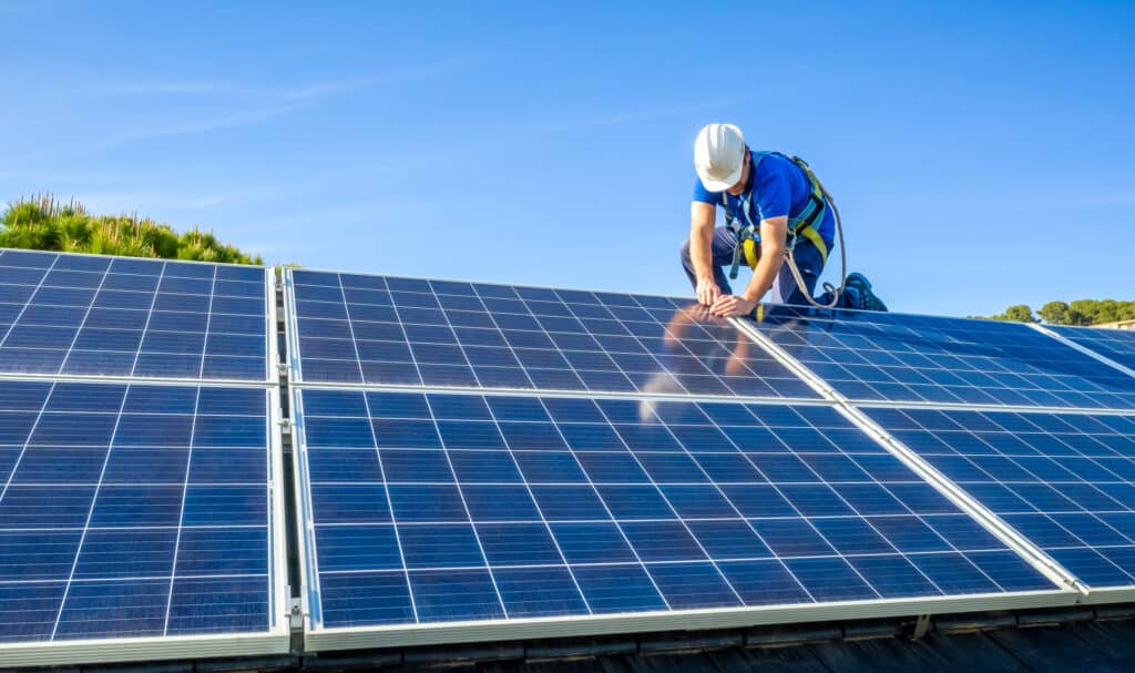 panneau-solaire-1024x607 man in white dress shirt and blue denim jeans sitting on white and black solar panel